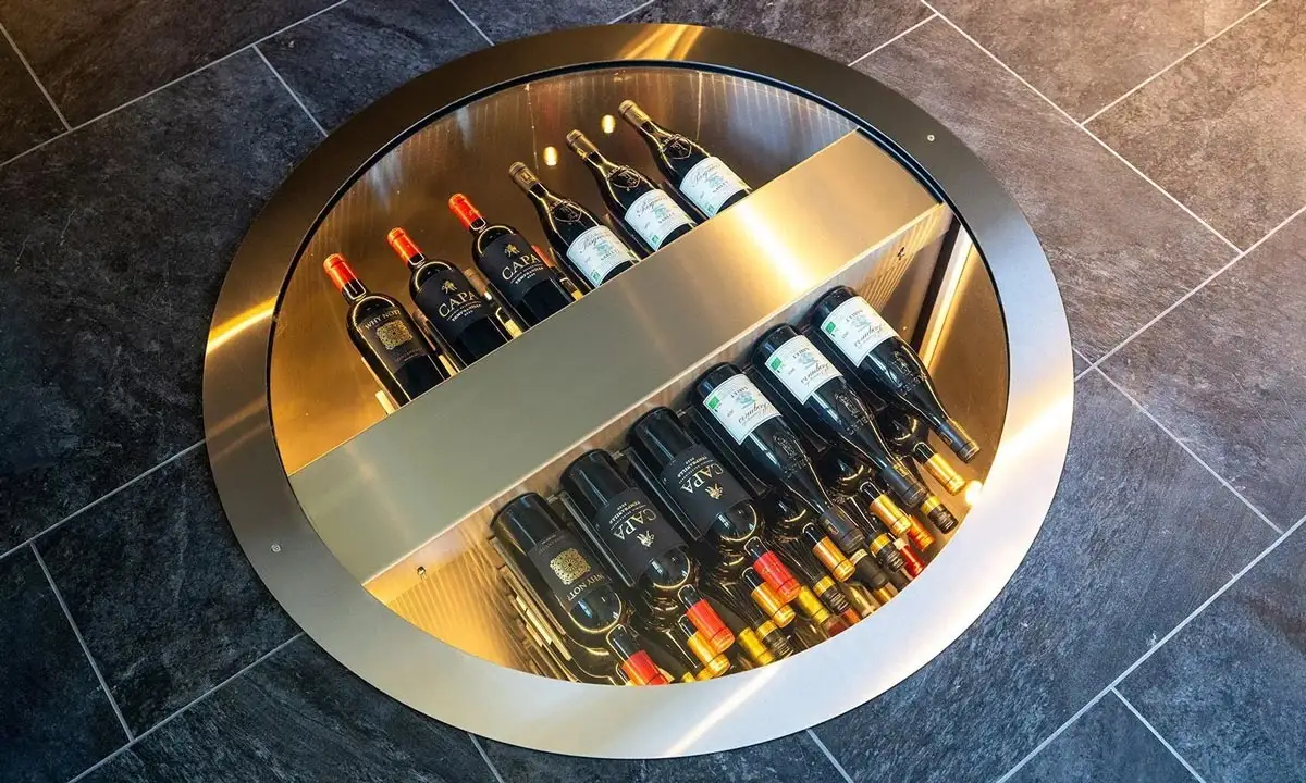 Round in-floor elevation wine cellar holding up to 108 bottles